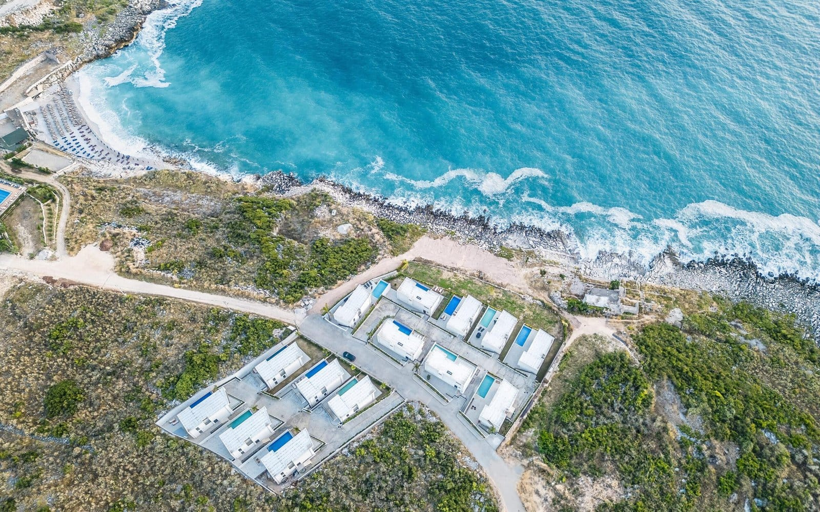 drone view of the palmera resort saranda project and the natural landscape with greenery and sandy beach and swimming pools